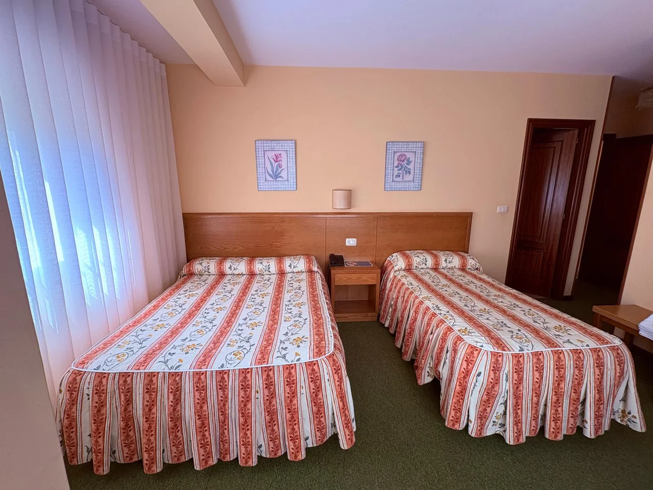 Habitación con dos camas separadas y colchas de rayas en El Bosque