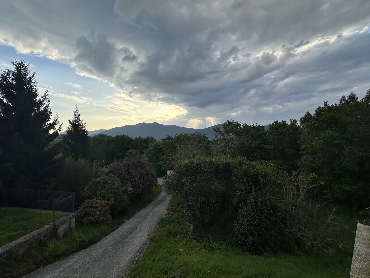 Zonas verdes y montañas bajo un cielo de nubes fotografiados desde El Bosque