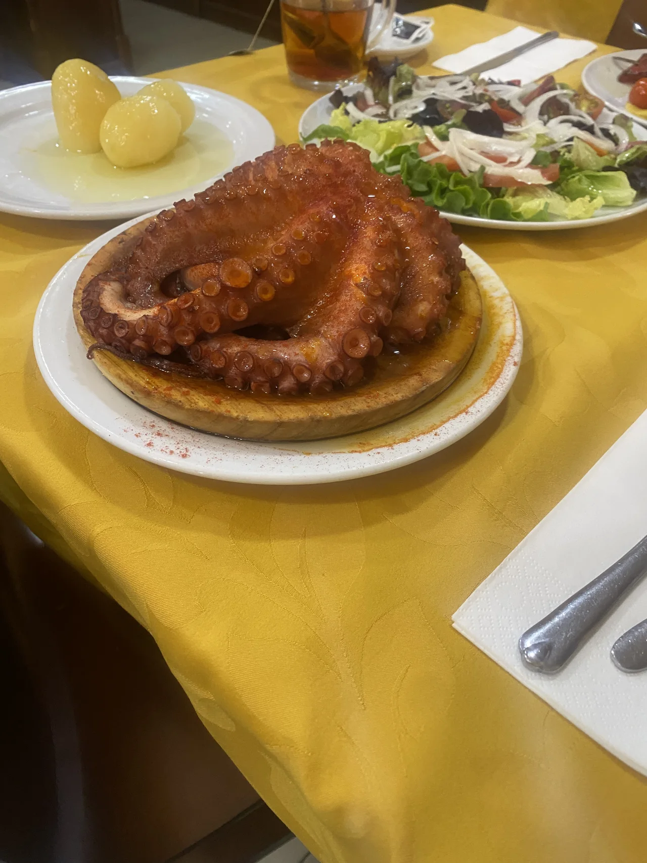Plato de pulpo sobre una mesa con mantel amarillo