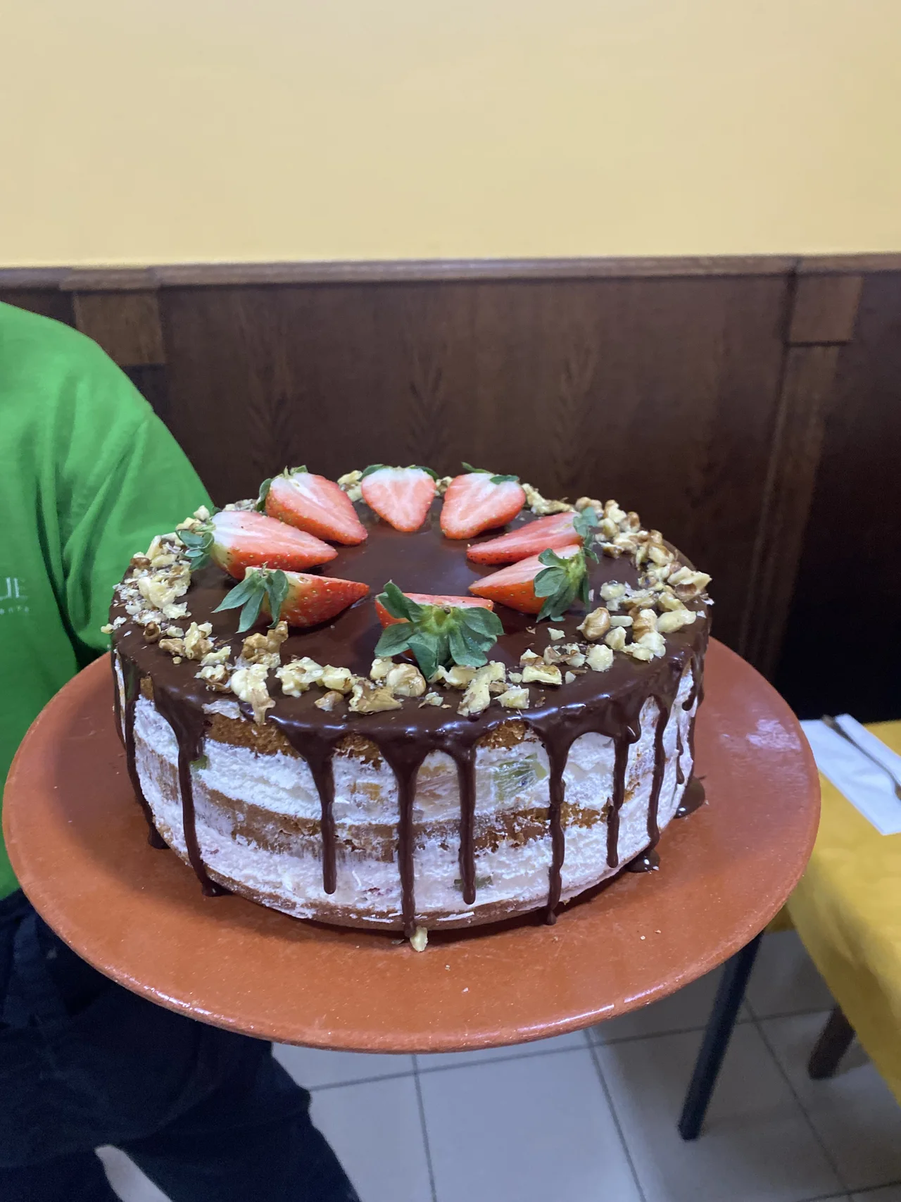 Tarta redonda con cobertura de chocolate y frutas en la parte superior