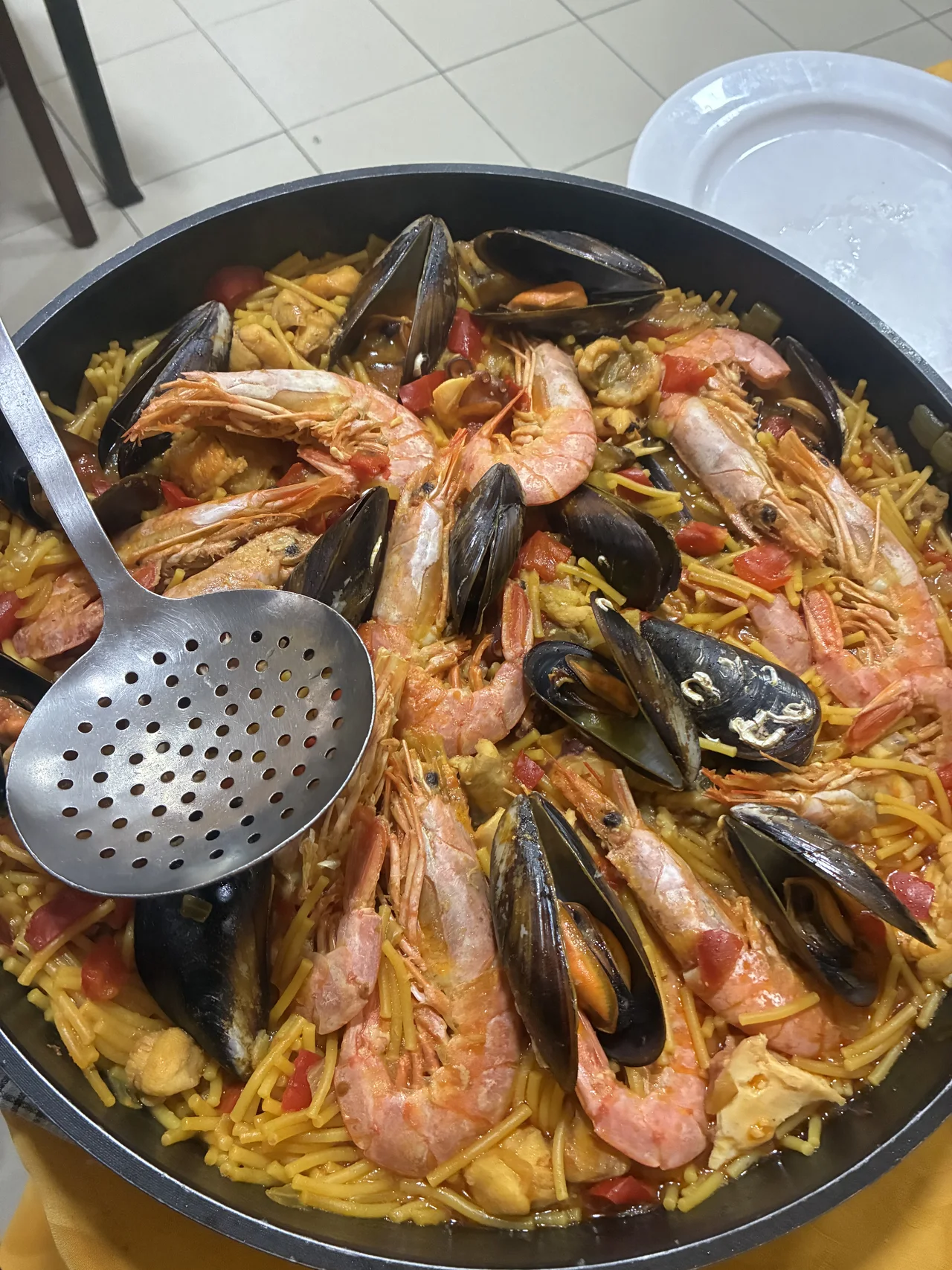Paella con marisco y un utensilio para servir