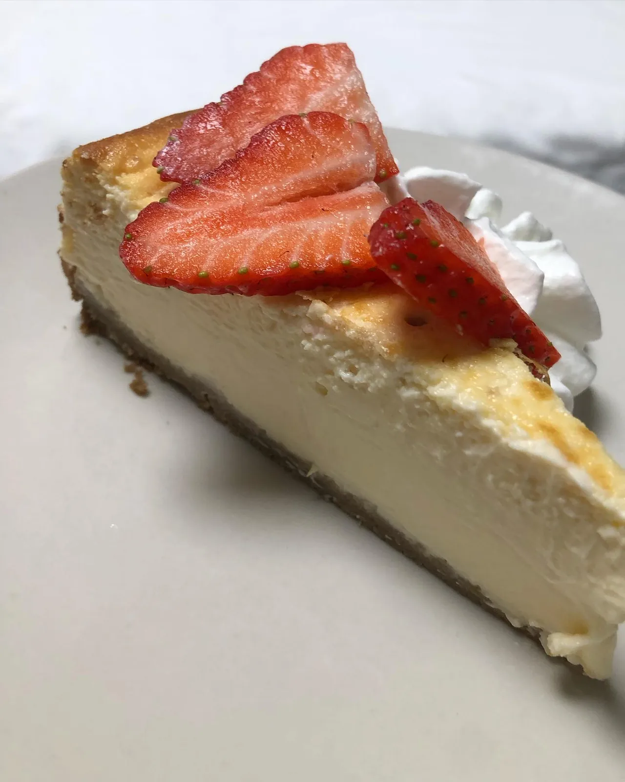 Porción de tarta de queso con fresas y nata en el restaurante El Bosque